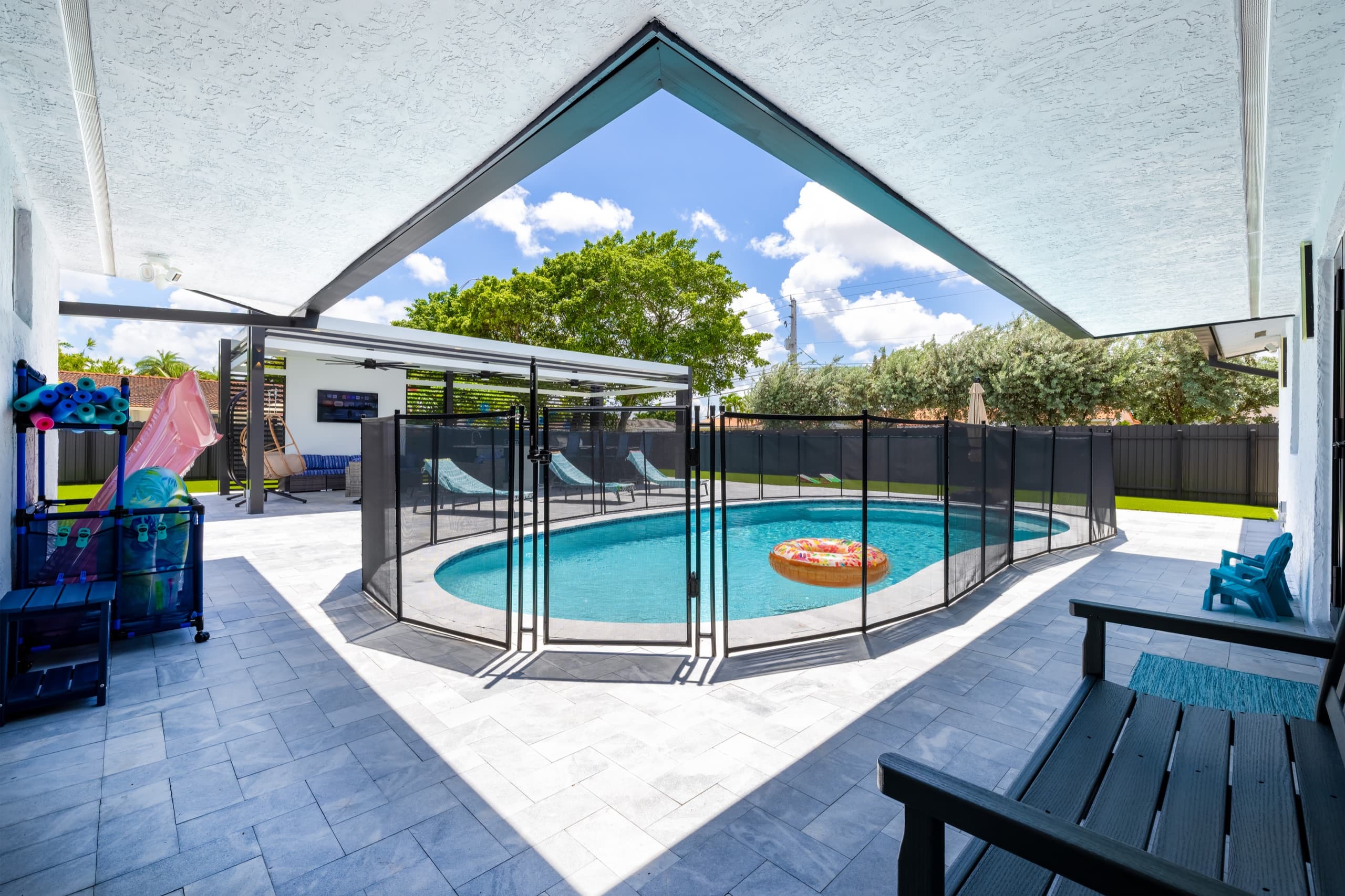 View from the covered porch toward the fenced pool and the pavilion beyond.
